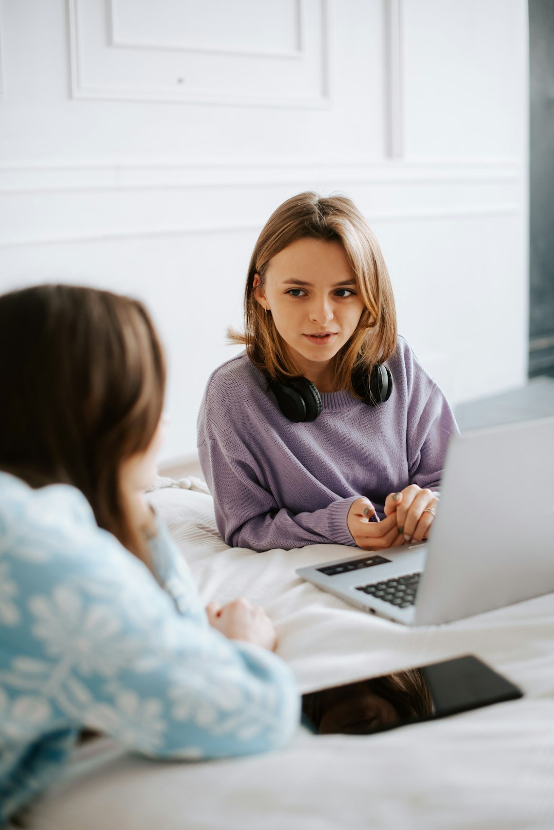 Home two-women-sitting-on-a-bed-looking-at-a-laptop-q1gtazumap8